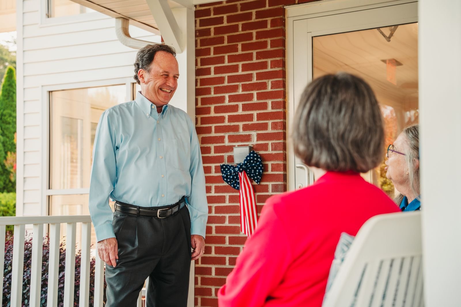 Chris Parker talking with neighbors on a front porch
